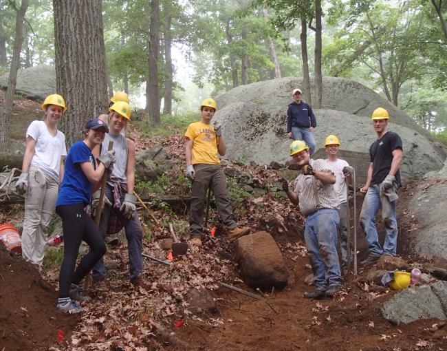 Volunteers excavate big rock from the trail.  